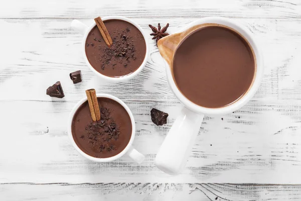 Hot chocolate drinks and chocolate pieces in white cup. top view