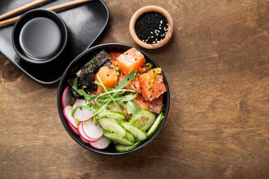 Pirinç, turp, salatalık, domates, susam ve yeşil soğanlı somon balığı..