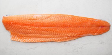 Gri arka planda taze çiğ somon balığı bifteği..