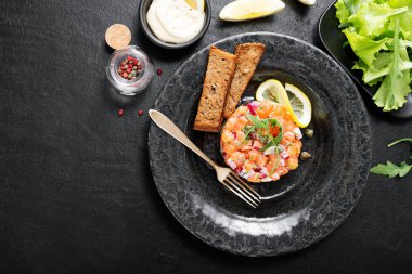 Kırmızı soğanlı somon tartar, avokado, roka ve ekmek tostu..