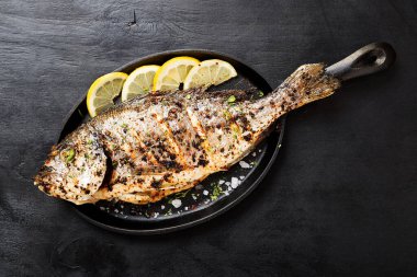 Mutfak masasında limonlu ızgara balık dorado..