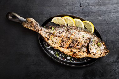 Mutfak masasında limonlu ızgara balık dorado..