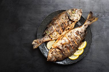 Mutfak masasında limonlu ızgara balık dorado..