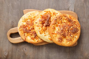 Ahşap bir masada peynirli taze pişmiş khachapuri..