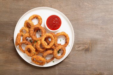 Lezzetli altın hırpalanmış, ekmekli ve ketçaplı kızarmış soğan halkaları..