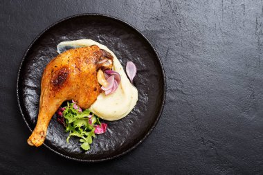 Kızarmış ördek bacağı, patates püresi ve taze salata..