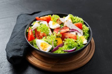 Fresh vegetable salad with chicken breast and eggs.	