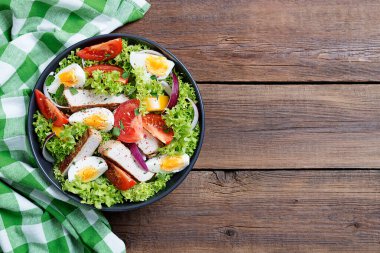 Fresh vegetable salad with chicken breast and eggs.	
