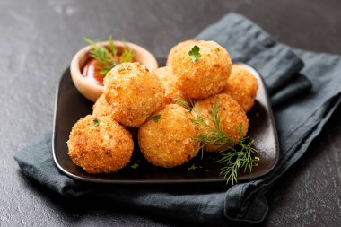 Potato croquettes - mashed potatoes balls breaded and deep fried, served with different sauce. clipart