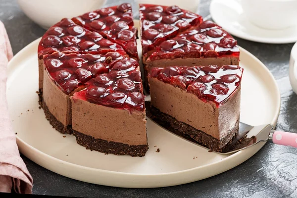 Cold chocolate cheesecake with cherry jelly.