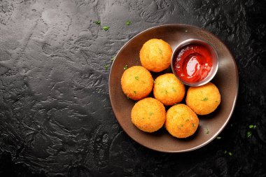 Mantar ve parmesan peyniri ile doldurulmuş ev yapımı Risotto Arancini, domates sosuyla servis edilir. Üst Manzara. siyah arkaplan