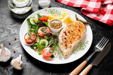 Taze sebze salatasıyla ızgara tavuk göğsü. Sağlıklı yemek, keto diyeti, diyet öğle yemeği konsepti. Siyah taş arka planda