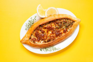 Geleneksel Türk mutfağı. Pita 'da Türk pizzası, sarı arka planda kıymalı ve peynirli. en üstteki görünüm