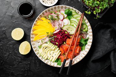 Taze salamura edilmiş somon, çeşitli sebzeler, yeşil soğanlar ve mikroyeşillikler. Siyah arka plan. Üst görünüm.