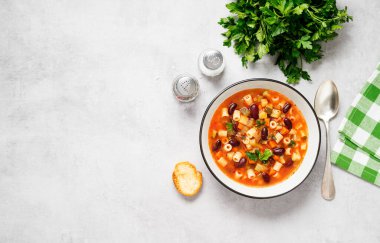 Taze sebze, makarna ve fasulyeden yapılmış sebze çorbası. Açık gri arkaplan, üst manzara. Metin için boşluk