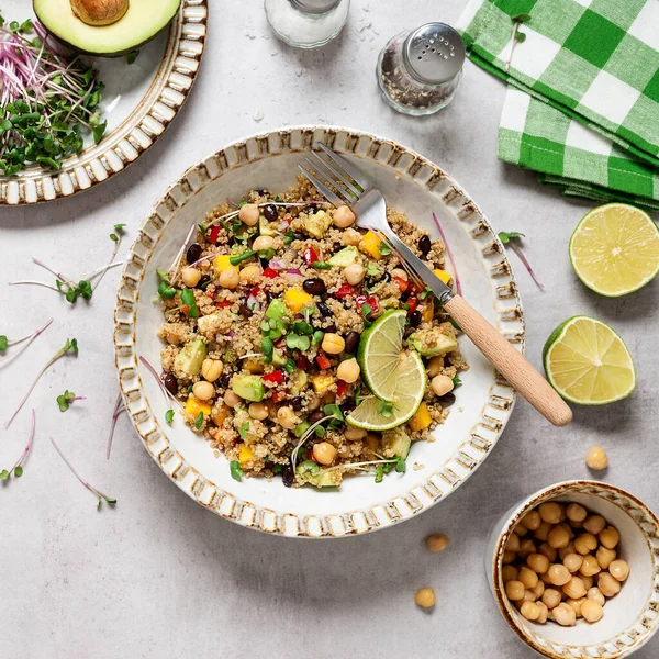 Healthy quinoa black bean salad with mango and avocado. Perfect for spring, summer, fall or winter. Gray stone background, top view.