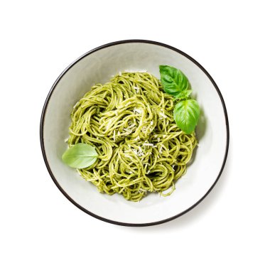 Pesto soslu makarna ve gri kasede taze fesleğen yaprağı. Beyaz arka planda izole edilmiş. Üst manzara..