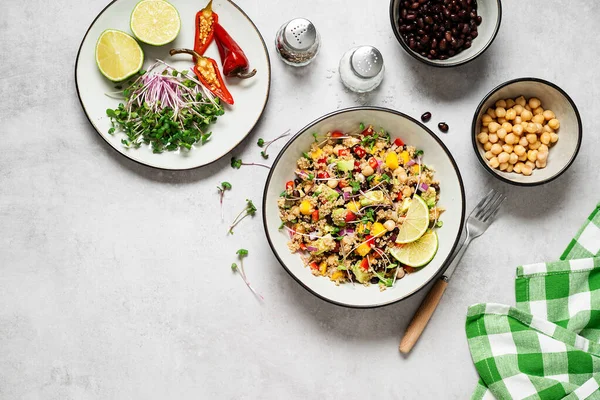Healthy quinoa black bean salad with mango and avocado. Perfect for spring, summer, fall or winter. Light gray stone background, top view.