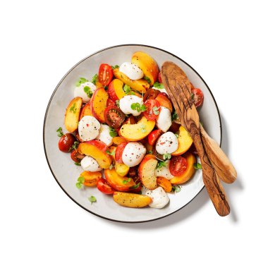 Mozzarella ve vişneli domatesli yaz şeftali Caprese salatası. Üst görünüm, beyaz arkaplanda izole