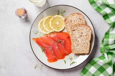 Sağlıklı kahvaltı sandviçleri için tuzlu somon dilimleri. Organik balık. Açık gri arkaplan. Üst görünüm.