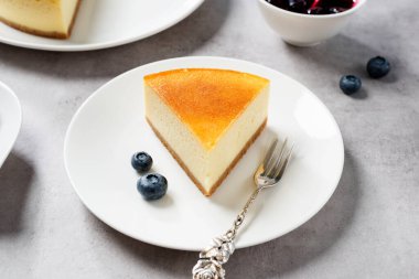 Tatlı - bir parça yaban mersini soslu New York peynirli kek ve taze böğürtlen.