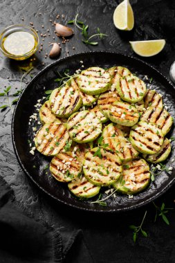 Siyah tabakta sarımsak soslu ızgara kabak dilimleri. .