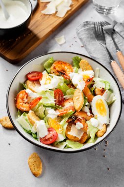 Parmesan peynirli taze karides Sezar salatası ve kızarmış ekmek. Gri arkaplan.