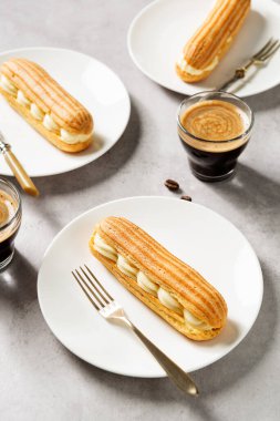 Vanilya kreması ve pudra şekerle dolu geleneksel Fransız ekleriName.