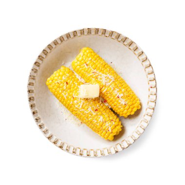Parmesan peyniri, tuz ve tereyağı ile servis edilen koçandaki mısır. Beyaz arka planda izole edilmiş. en üstteki görünüm