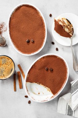 Klasik İtalyan Tatlısı Tiramisu üstü seramik bir tabakta kakao ile kaplanmış. Açık gri arkaplan. en üstteki görünüm