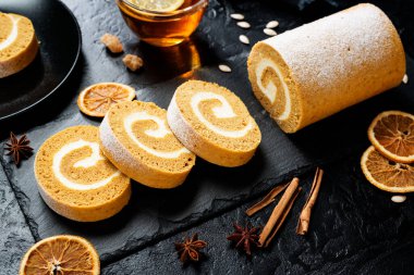 Krem peynirli balkabaklı kek rulosu. Sonbahar Fırını. Siyah arkaplan