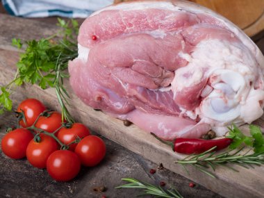 Biberiyeli çiğ domuz inciği, ahşap arka planda kiraz domatesleri ve biber. Mesaj için yer var. Yukarıdan görüntüle.