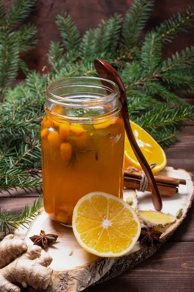 A healthy drink from sea buckthorn on a wooden table. Glass beakers with a wooden spoon.
