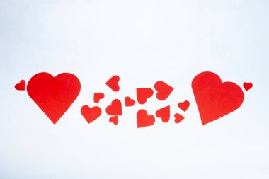 Beyaz arka planda farklı boyutlarda kırmızı kalpler. Sevgililer Günü konsepti.