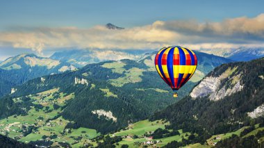 Panoramic view of mountains with a hot air balloon clipart