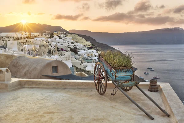 Carrinho em um terraço em Oia ao nascer do sol — Fotografia de Stock