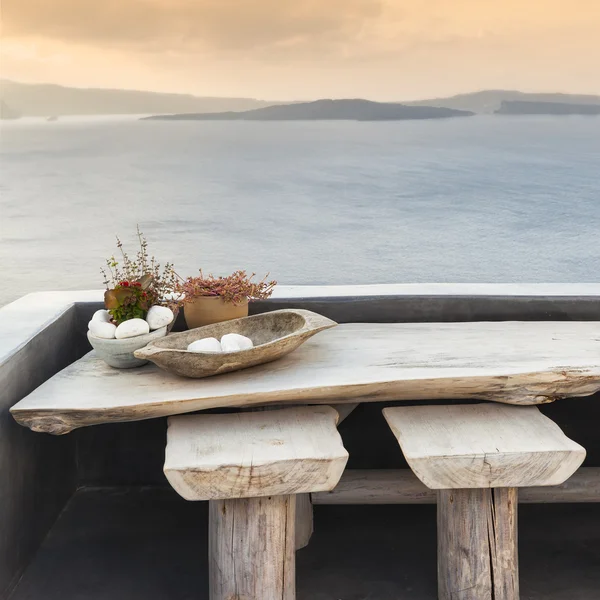 Ahşap masa ve tabureler Santorini'de bir terasta