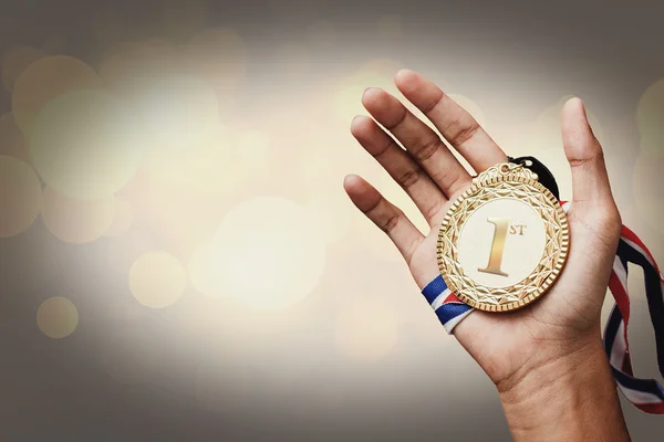 Mão segurando um troféu de ouro — Fotografia de Stock