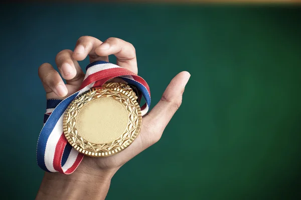 Mão segurando um troféu de ouro — Fotografia de Stock