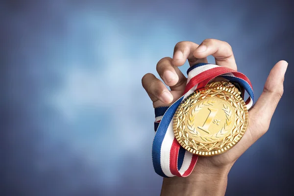 Mão segurando um troféu de ouro — Fotografia de Stock