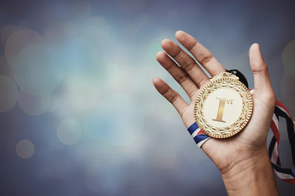 Mão segurando um troféu de ouro — Fotografia de Stock