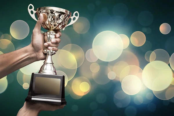 Hand holding up a gold trophy — Stock Photo, Image