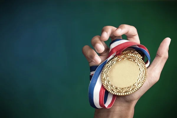 Mão segurando um troféu de ouro — Fotografia de Stock