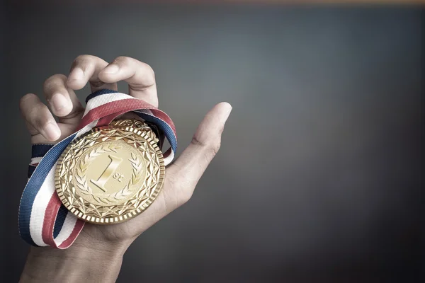 Mão segurando um troféu de ouro — Fotografia de Stock