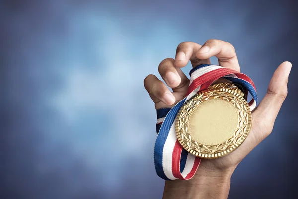 Mão segurando um troféu de ouro — Fotografia de Stock