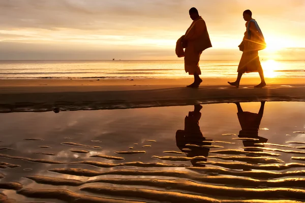 Silhouetten von Mönchen am Strand von hua hin Thailand Stockfoto