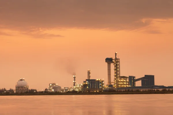 Sonnenuntergang der Ölraffinerie mit Reflexion, petrochemische Anlage Stockbild