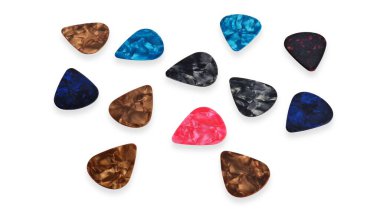Farklı plastik gitar penaları, aynı zamanda plectrum olarak da bilinir, beyaz arka plana saçılmış.