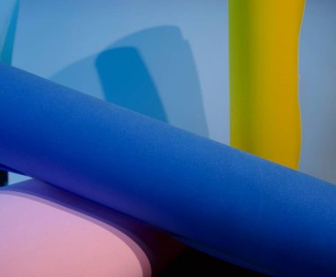 Mavi arkaplana karşı renkli geometrik şekillere ve gölgelere sahip soyut bileşim