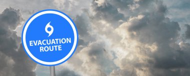 Bulutlu arkaplanda tahliye yolu işareti